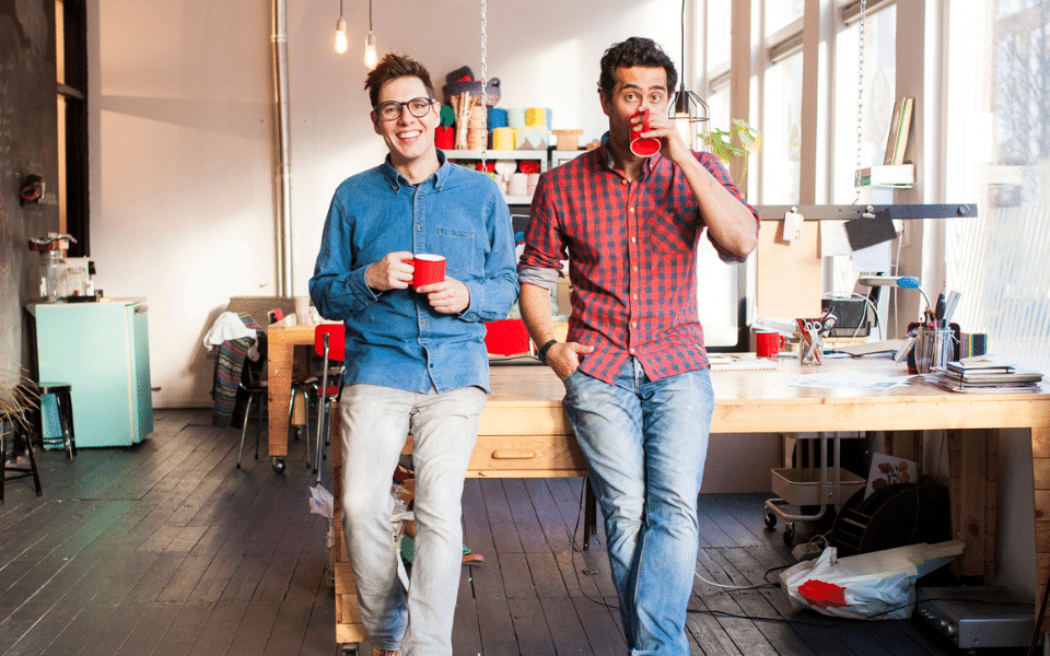 To menn som står og drikker kaffe 